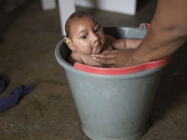 Banhos de balde ajudam a acalmar José Wesley, que é agitado como outros bebês com casos recentes de microcefalia, associada ao zika vírus (Foto: BBC)