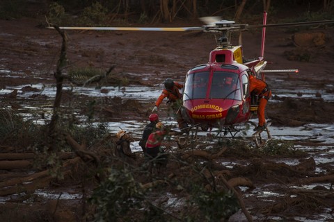Equipe dos bombeiros resgata corpo no meio da lama