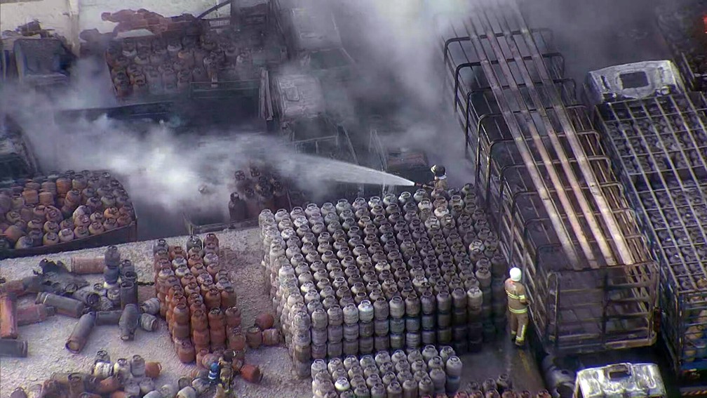 Bombeiro resfria bujões no combate ao incêndio em depósito — Foto: Reprodução/TV Globo