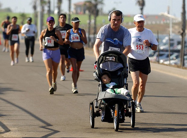 Pai correndo com o filho no carrinho (Foto: Kirby Lee/Getty Images)