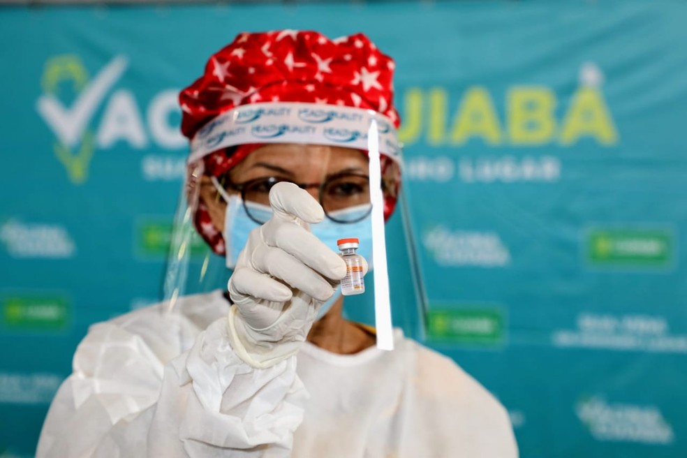 Técnica de enfermagem Lucinei Rodrigues, de 59 anos, que atua no setor de imunização do SUS há 21 anos, exibe a vacina contra Covid-19 momentos antes do lançamento da campanha, em Cuiabá — Foto: Luiz Alves/Secom