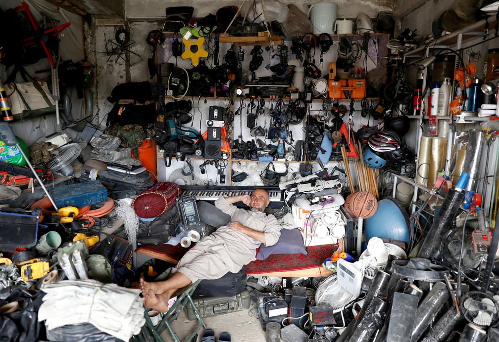 5 de julho - Afegão descansa em loja onde vende produtos usados, perto da base aérea de Bagram, na província de Parwan, no Afeganistão — Foto: Mohammad Ismail/Reuters