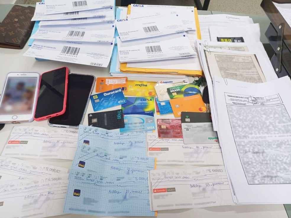 Cartões, cheques, celulares e valores em espécie foram apreendidos com as suspeitas — Foto: Polícia Civil
