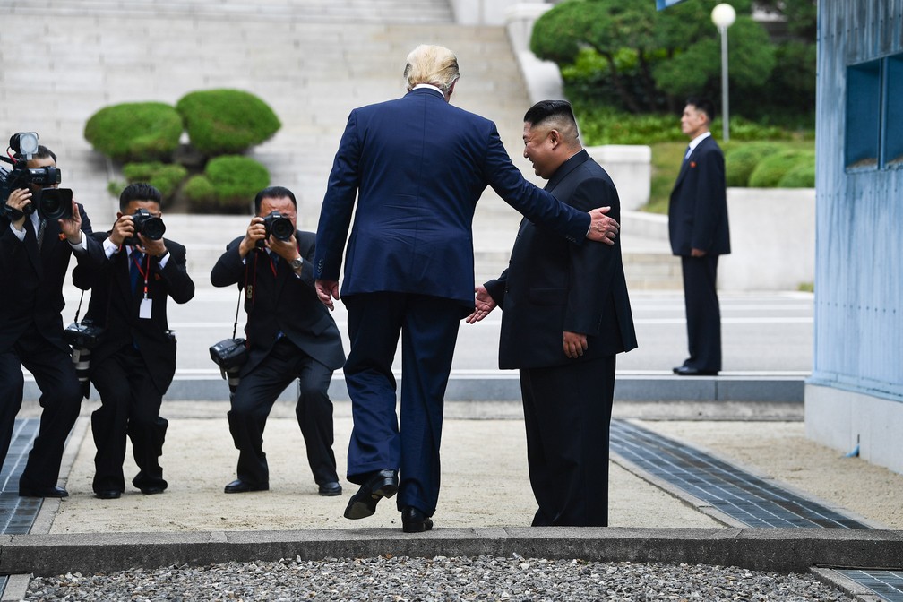 30 de junho - O presidente dos Estados Unidos, Donald Trump, cruza a fronteira e se tornou o 1º presidente dos EUA a pisar em solo norte-coreano, acompanhado pelo líder norte-coreano, Kim Jong-un. O momento ocorreu após simbólico aperto de mãos na Zona Desmilitarizada entre as Coreias do Norte e do Sul — Foto: Kevin Lamarque/Reuters