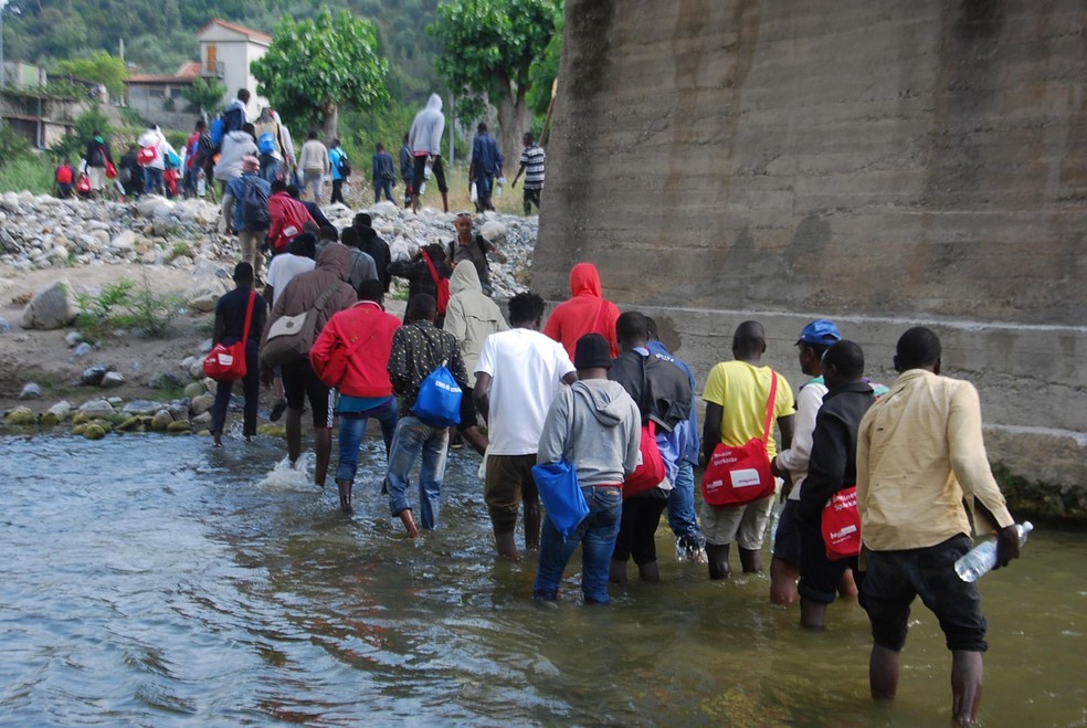 Imigrantes cruzam rio na Itália perto da cidade de Ventimiglia, a caminho da França 