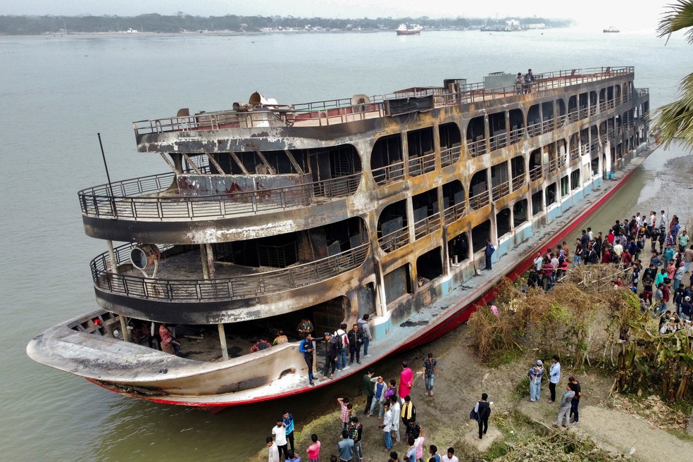 Barco de passageiros queimado ancorado na margem do rio Sugandha, em Bangladesh,  — Foto: Reuters